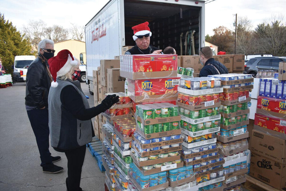 Members of the Downtown Franklin Rotary unload a truck provided by Shelley and Mike Moeller of Harpeth True Value